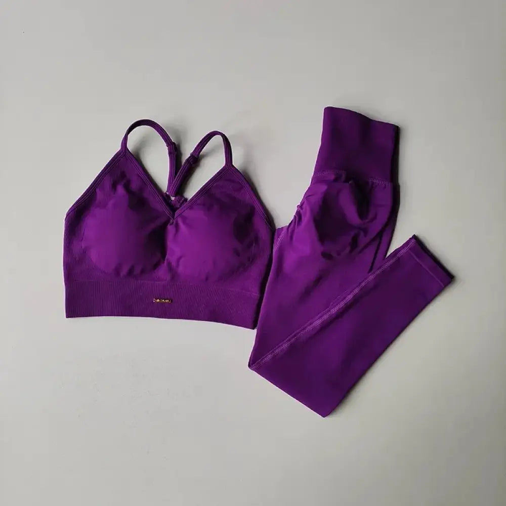 Ensemble sportif deux pièces violet comprenant un soutien-gorge avec bretelles croisées et un legging assorti.
