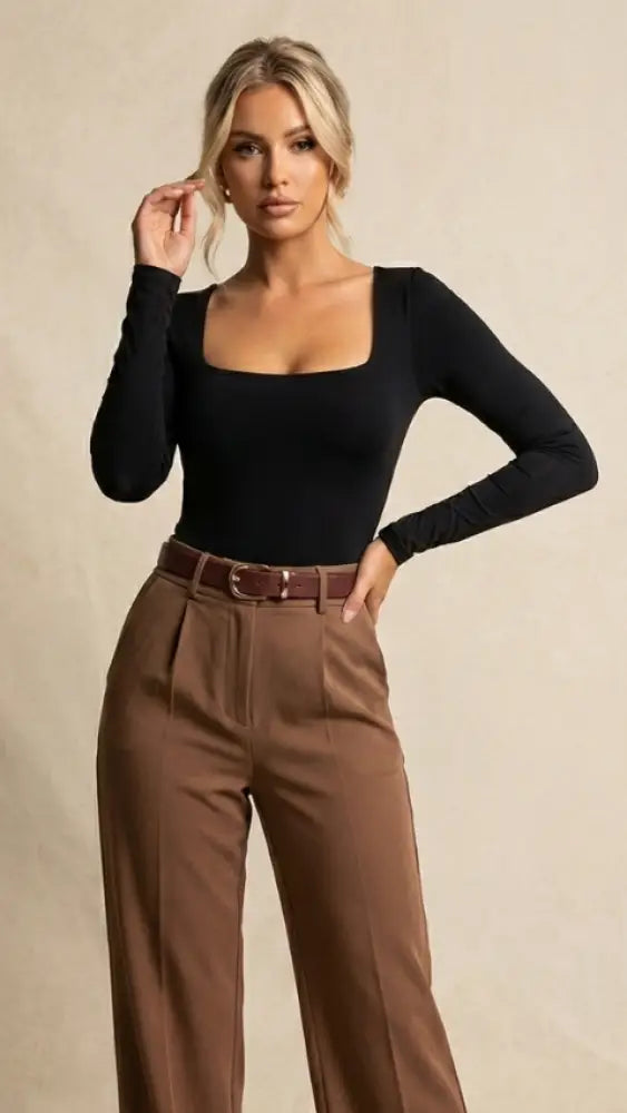 shooting photo luxibre d'une femme blonde élégante portant un body noir et un pantalon chic marron