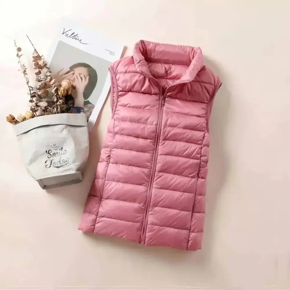 Doudoune sans manche plume rose matelassée ultra légère avec coupe cintrée col montant et fermeture zippée frontale