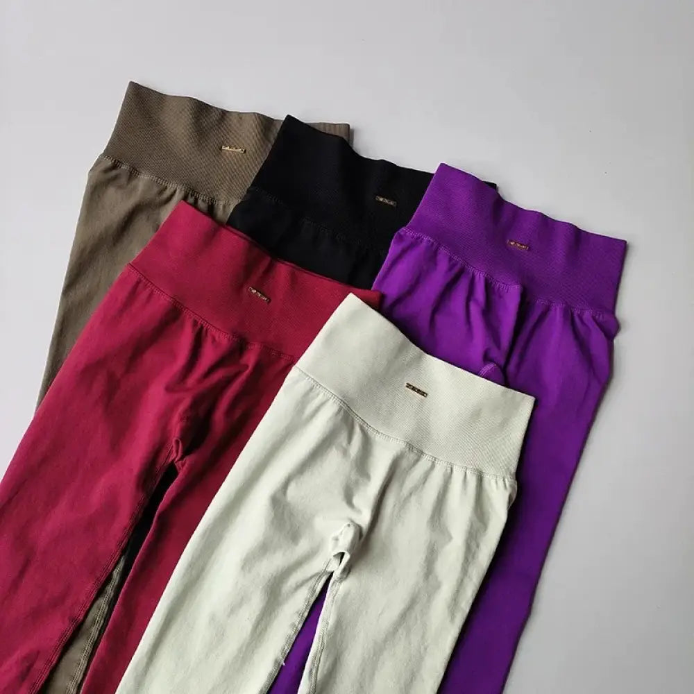Cinq paires de leggings taille haute en couleurs unies incluant beige, noir, rouge, crème et violet.
