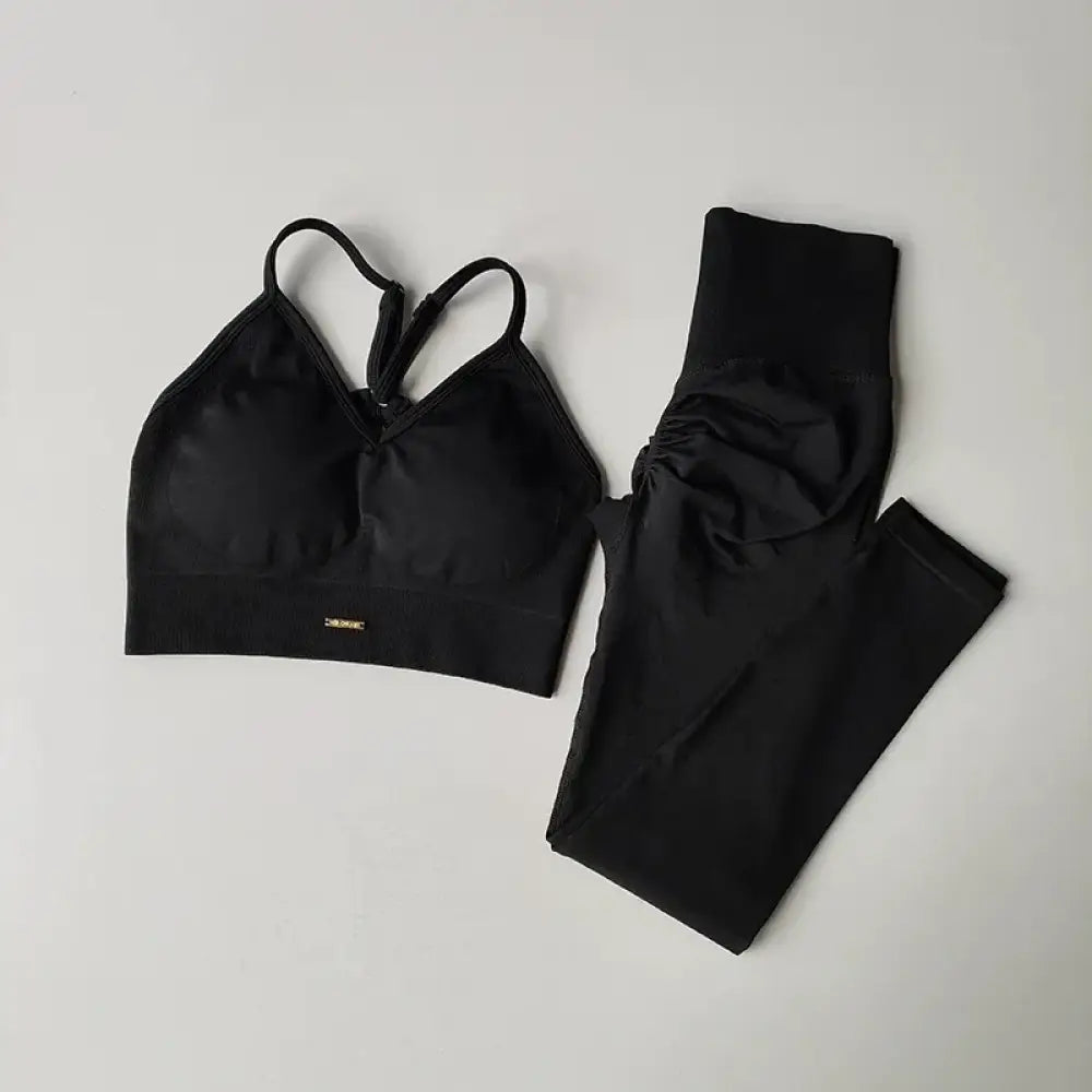 Ensemble deux pièces athlétique noir avec un soutien-gorge à bretelles croisées et des leggings taille haute avec détails froncés